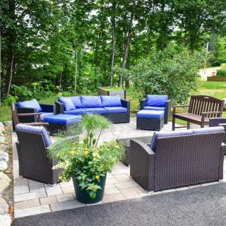 A cozy outdoor patio with comfortable furniture and lush greenery.