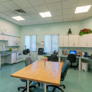A spacious office area with desks, computers, and a kitchenette.