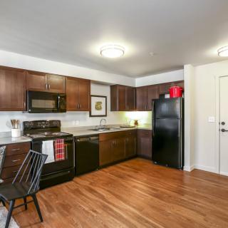 Modern kitchen with wooden cabinets and hardwood flooring.