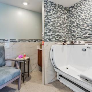 A modern bathroom featuring a walk-in tub and stylish tile accents.