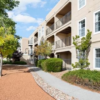 A scenic view of an apartment complex surrounded by greenery and walkways.