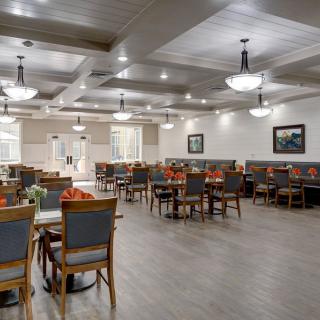 A spacious and elegantly designed restaurant dining area with neatly arranged tables and chairs.