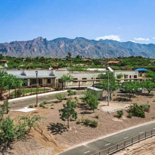 A scenic view of a desert landscape with buildings and mountains in the background under a clear blue sky.