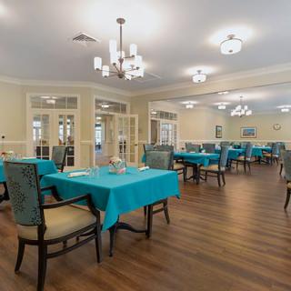 An elegant dining room with turquoise tablecloths and chandeliers.