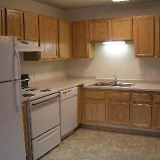 A simple kitchen setup with wooden cabinets and standard appliances.