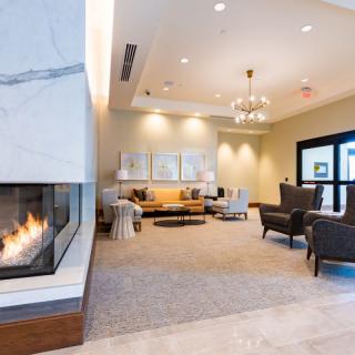 A modern lobby with a cozy fireplace and comfortable seating.