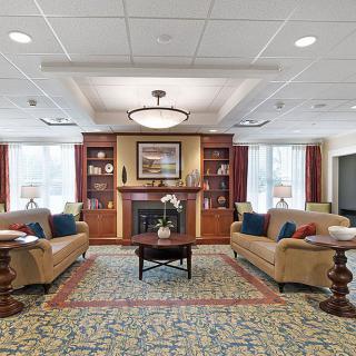 A cozy living room with sofas, a fireplace, and elegant decor.