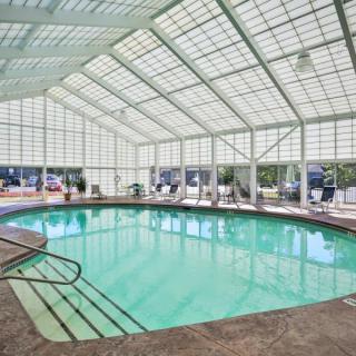 A spacious indoor swimming pool with a glass-paneled ceiling.