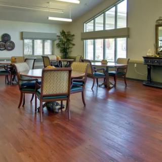 A spacious dining area with elegant tables and chairs, featuring large windows that allow natural light to fill the room.