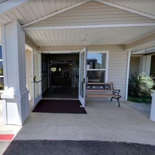 A view of a building entrance with a porch and bench.