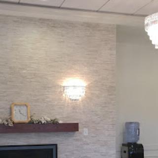 A modern living space featuring a textured wall, stylish lighting, and minimalist decor.