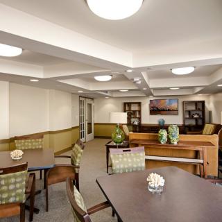A modern interior room with tables, chairs, and decorative elements.