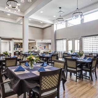 An elegant dining room with neatly arranged tables and chairs, featuring stylish lighting and decor.