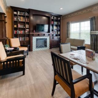 A cozy living room with a fireplace, bookshelves, and comfortable seating.