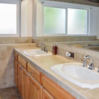 A modern bathroom featuring a double sink vanity with ample countertop space and a large mirror.