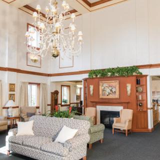 A cozy and elegant lobby featuring a chandelier, tasteful furniture, and a warm atmosphere.