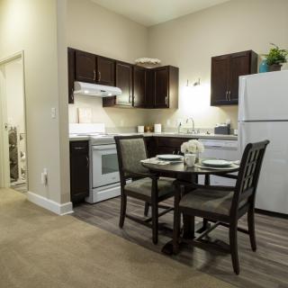 A cozy apartment kitchen with a dining table and modern appliances.