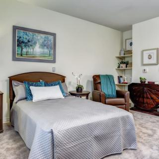 A cozy bedroom with a single bed, armchair, and decorative elements.