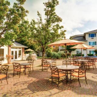 A charming outdoor patio with tables and umbrellas set amidst a scenic setting.