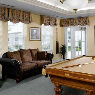 A cozy game room featuring a pool table and a comfortable sofa.