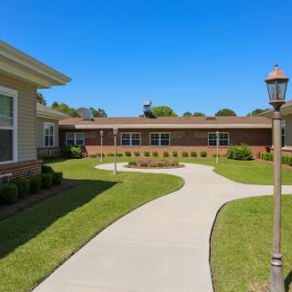 A well-maintained pathway leading through a landscaped area towards the building.