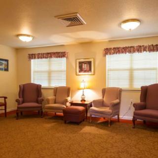 A cozy living room with several chairs arranged around a central lamp.