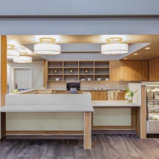 A modern hotel reception area featuring wooden decor and contemporary lighting.