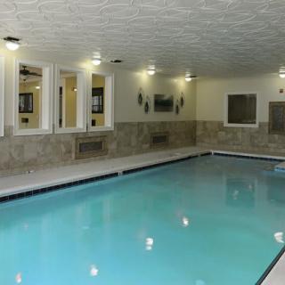 An indoor swimming pool with tiled walls and ceiling lighting.