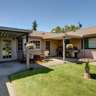 A cozy backyard patio with outdoor furniture and a well-maintained lawn on a sunny day.