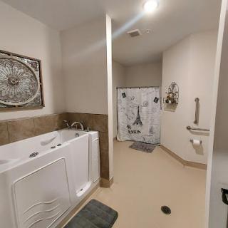 A spacious and modern bathroom featuring a whirlpool tub, shower, and elegant decor.