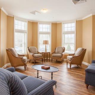 A cozy living room with arranged seating and large windows.