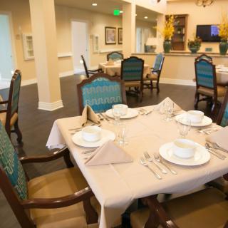 An elegantly set dining table in a restaurant with stylish chairs and neatly arranged tableware.