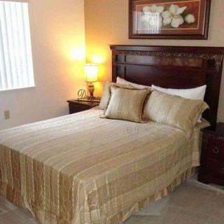 A cozy bedroom with a neatly made bed and warm lighting.
