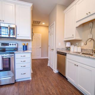 A modern kitchen with stainless steel appliances and white cabinets.
