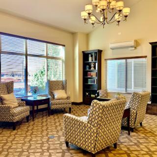 A cozy and inviting seating area with stylish chairs, a chandelier, and ample natural light.