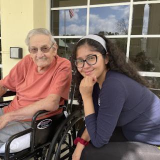 A joyful moment shared between an elderly man and a young woman, enjoying the outdoors.