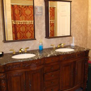 A double sink bathroom vanity with dark wood cabinetry and two mirrors.