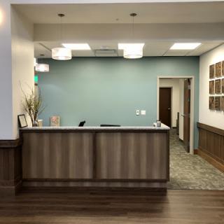 A modern office reception area featuring a sleek design and warm wooden accents.