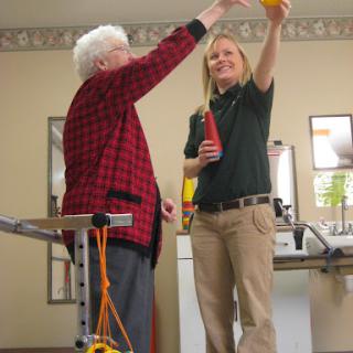 A caregiver and an elderly individual engage in a joyful interaction, highlighting meaningful support and companionship.