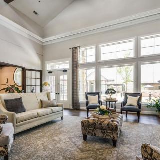 A spacious and well-lit living room with elegant furniture and large windows.