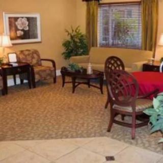 A cozy living room with a sofa, armchair, table, and decorative elements.