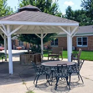 A charming gazebo surrounded by outdoor furniture on a sunny day.