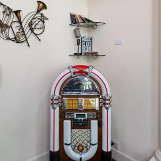 A vibrant jukebox complemented by musical decor on the wall.