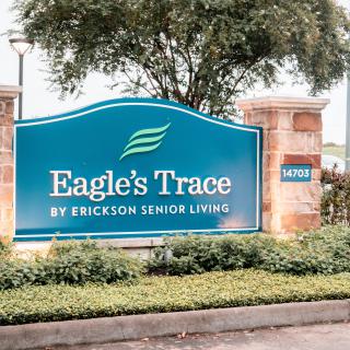 Entrance sign for Eagle's Trace by Erickson Senior Living, surrounded by greenery.