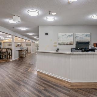 A modern reception area with a front desk and artwork on the walls.
