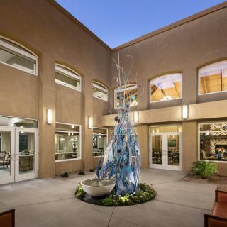 A well-lit courtyard with a central fountain surrounded by a modern building.