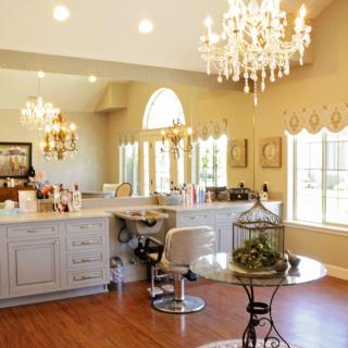 A luxurious salon interior featuring chandeliers, large mirrors, and elegant decor.