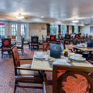 A well-furnished dining room with neatly arranged tables and chairs.