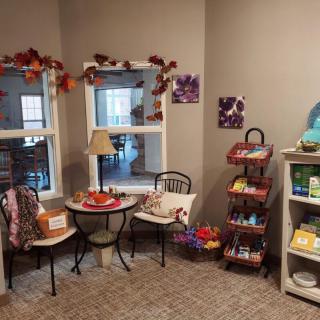 A cozy, autumn-themed interior with small tables and decorative shelves.