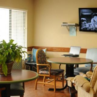 A cozy waiting room with comfortable seating, a television, and natural light.